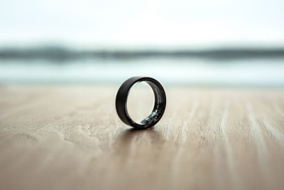Mattamusta Ultrahuman Ring Air -älysormus puupöydällä