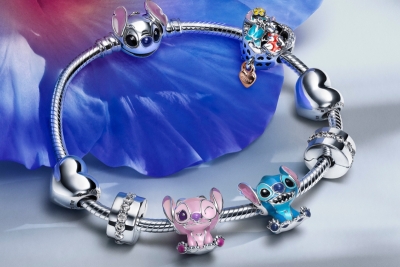 Pandoran 2025 koru-uutuudet, jotka sisältävät Lilo & Stitch -heloja. Kuvassa on Disney-heloja ja rannekoru, jossa yksityiskohtaiset koristeet.