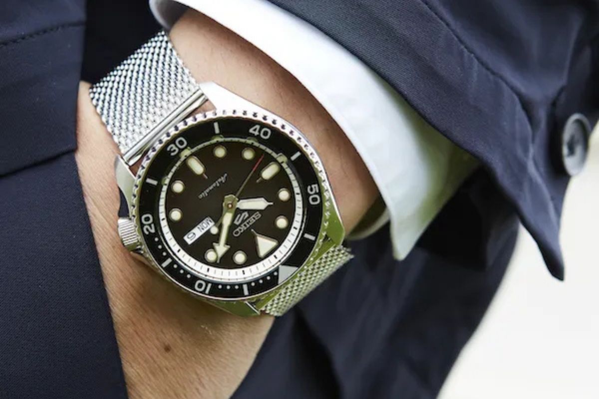 Kuvassa Seiko 5 Sports sarjan kello miehen ranteessa, jolla on päällään puku