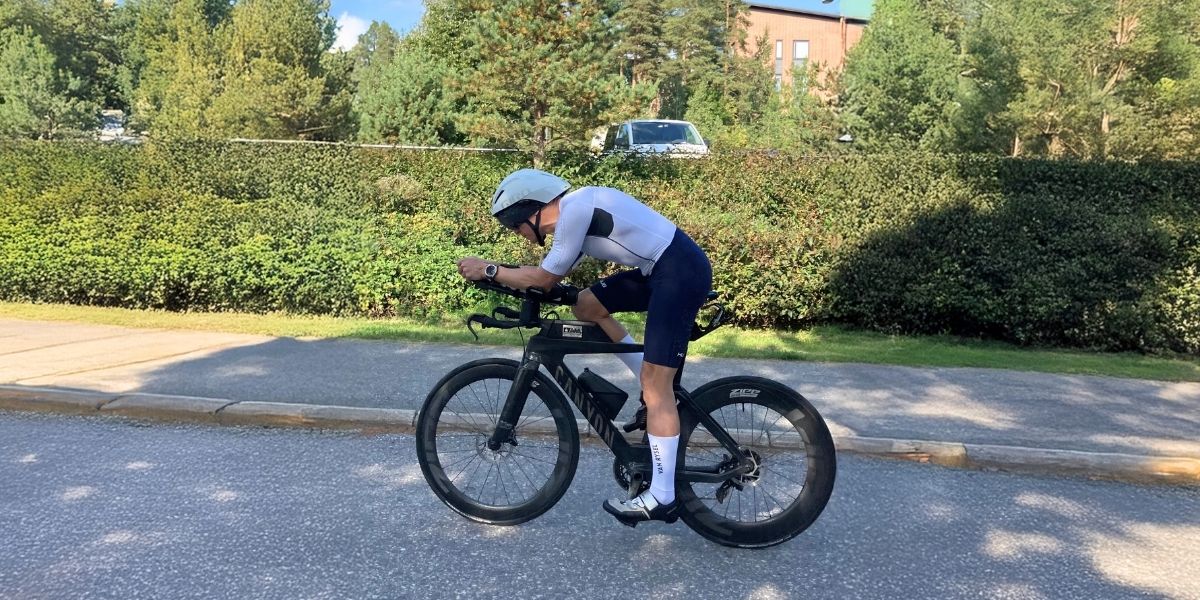 Triathlonharjoitus pyöräosuudella aerodynaamisessa ajoasennossa Garmin Fenix 8 -urheilukello ranteessa